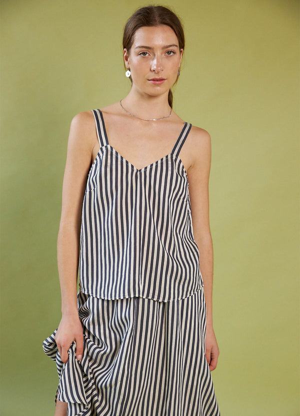 Woman wearing a Daylight Moon black and white striped dress against a green background