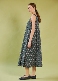 Woman wearing a Daylight Moon Liberty Print floral dress against a solid background