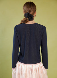 Person wearing a Daylight Moon navy long-sleeve top with a green background