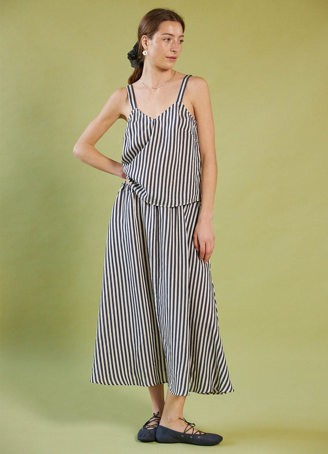 Woman wearing a Daylight Moon black and white striped dress against a green background